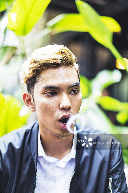 抽烟的年轻亚洲男人图片素材