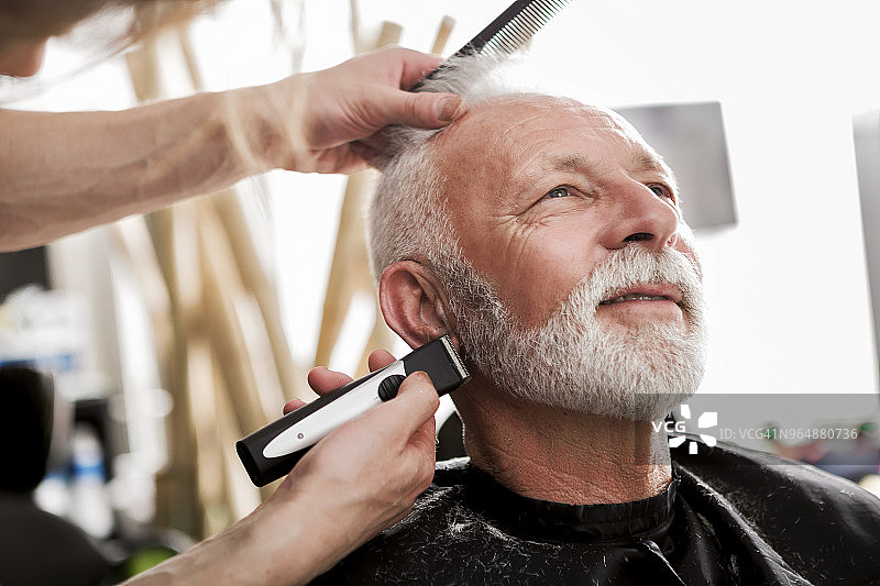 在理发店修剪胡须的老年男人图片素材