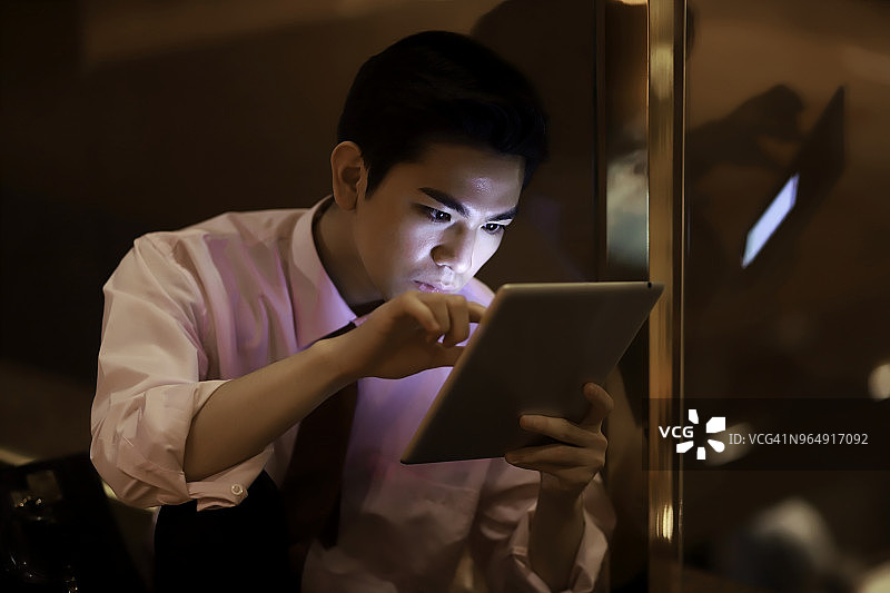 夜晚在城市里使用平板电脑的商人图片素材