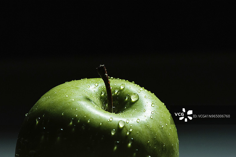 黑色背景下的湿绿苹果特写图片素材