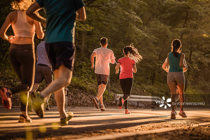 日落时马拉松比赛中跑步者的背影图片素材