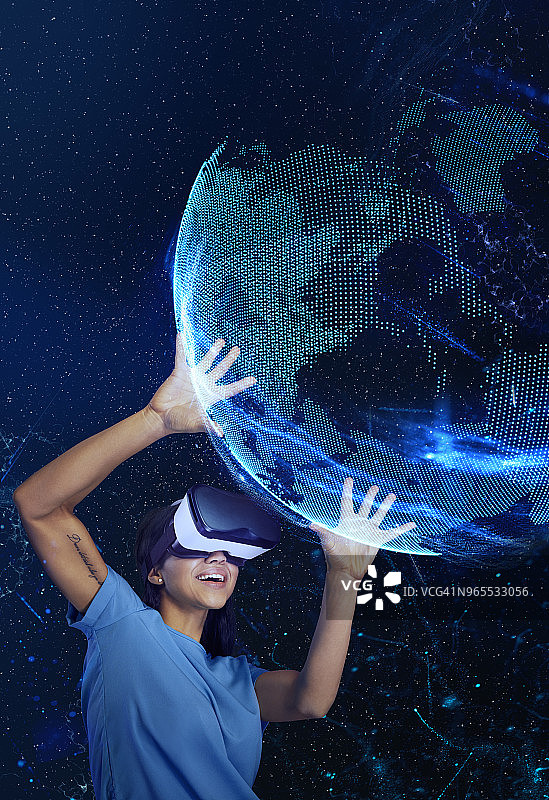 探索虚拟现实的女人，手持全息地球模型图片素材