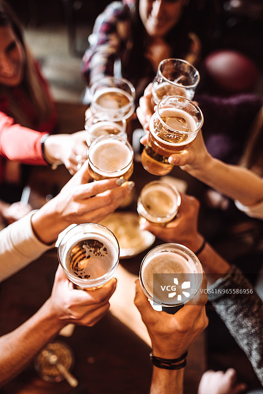 人们在酒吧里用啤酒敬酒图片素材