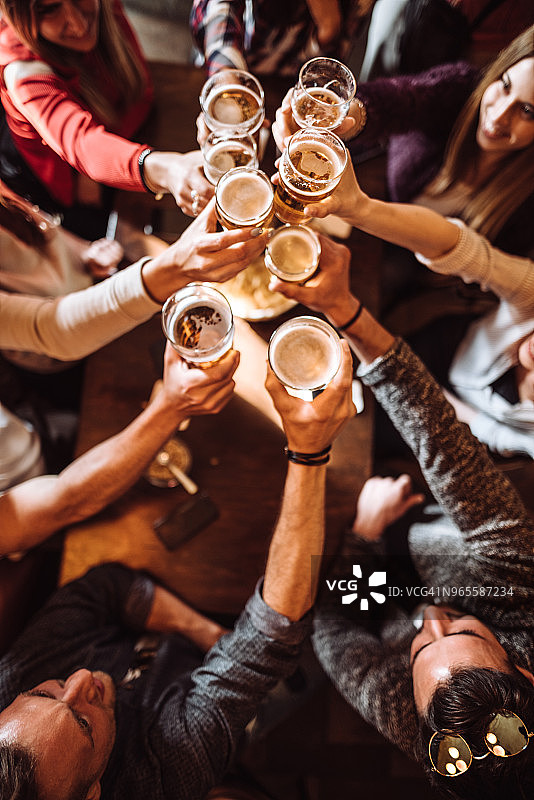 人们在酒吧里用啤酒敬酒图片素材