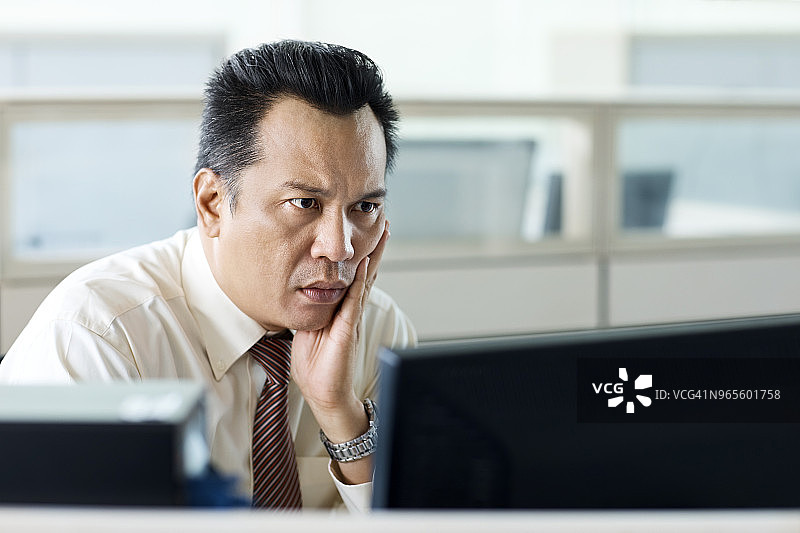 紧张的商人看着电脑屏幕图片素材