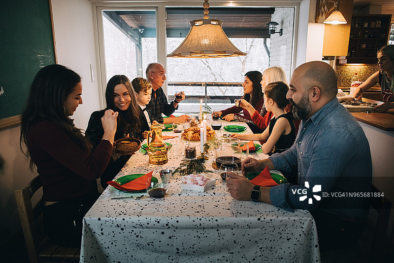 一家人在圣诞节期间在餐桌旁用餐图片素材