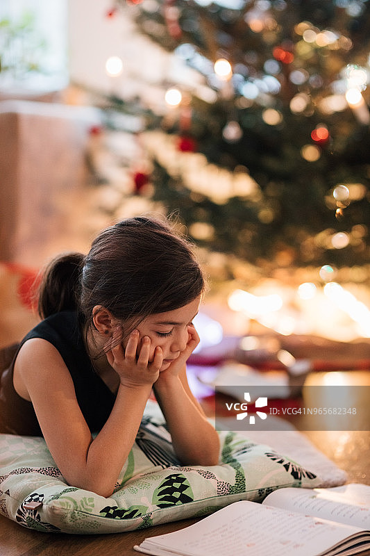 拿着圣诞礼物坐在客厅里的多代同堂家庭图片素材