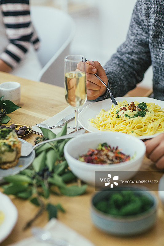 朋友们在餐桌上用餐的局部照片图片素材