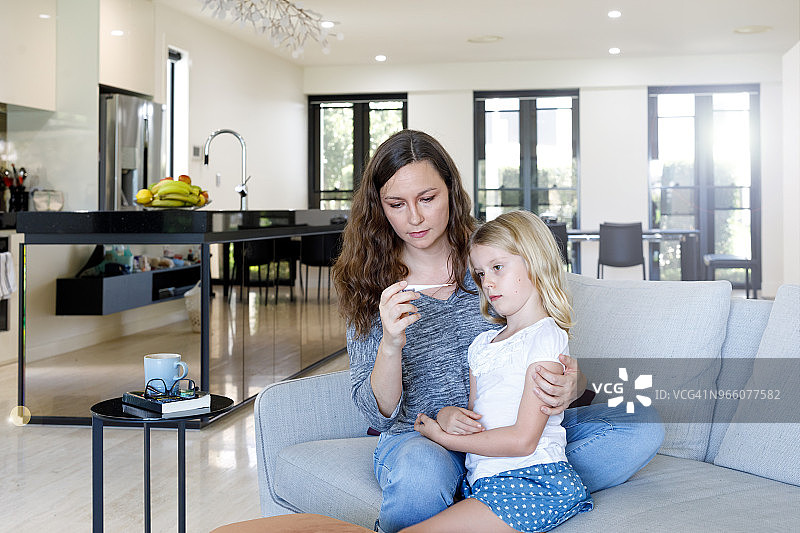 母亲用温度计给孩子量体温图片素材