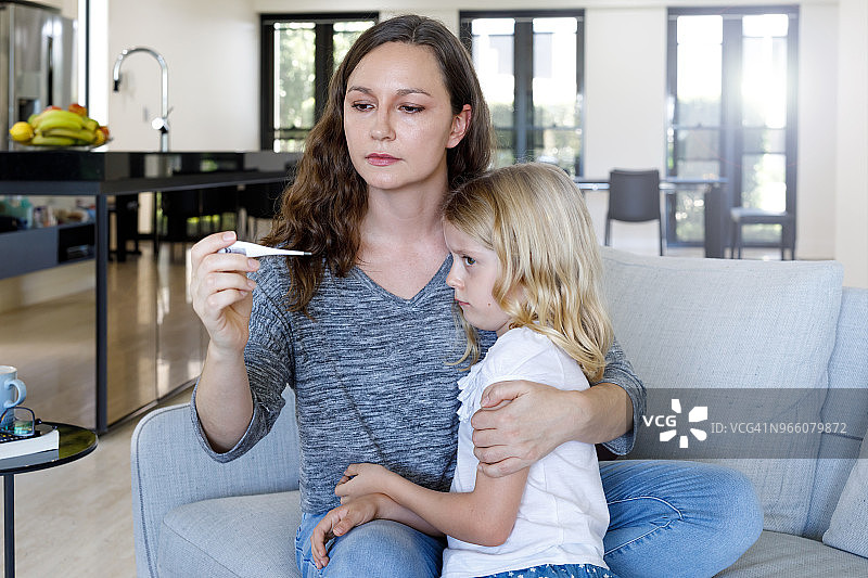 母亲用温度计给孩子量体温图片素材