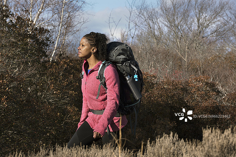 女徒步者走在美国马萨诸塞州纽伯里波特灌木丛前图片素材