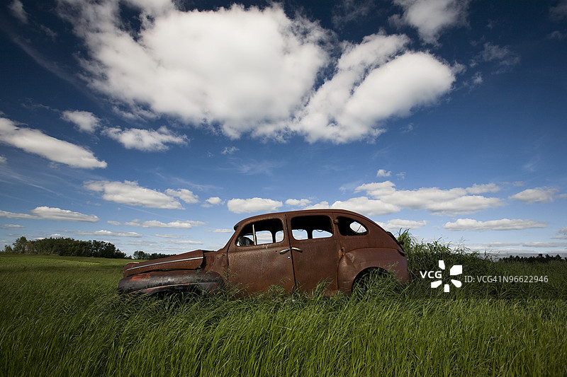 一辆被遗弃的经典汽车在草原上图片素材