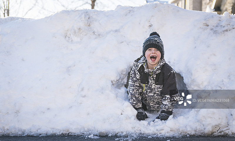 在雪地里玩耍的张着嘴的男孩图片素材