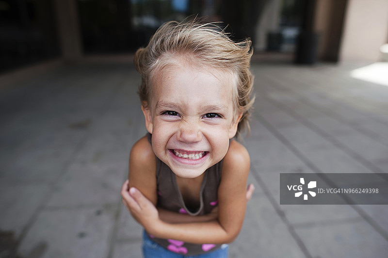 双臂交叉站在人行道上的女孩肖像图片素材