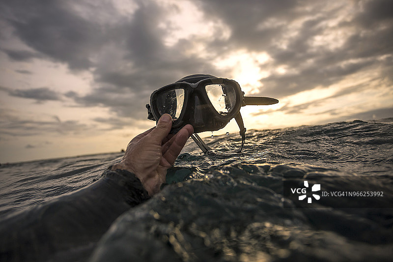 在海上手持游泳镜的局部照片图片素材