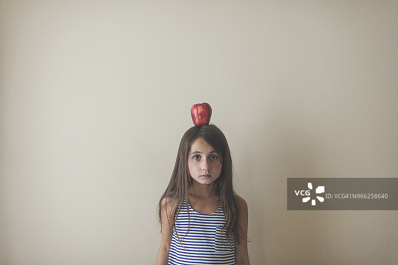 头顶苹果的女孩肖像图片素材