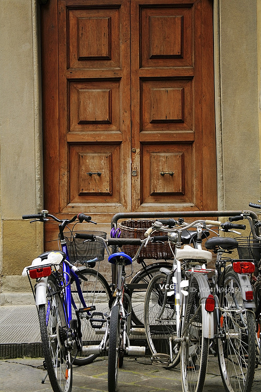 自行车停放在木门外的自行车架上图片素材