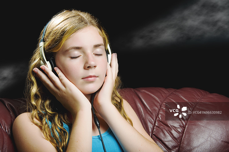 年轻女孩戴着耳机听音乐图片素材