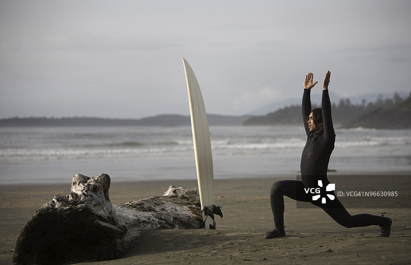冲浪者在不列颠哥伦比亚省托菲诺附近的考克斯湾海滩上伸展身体图片素材