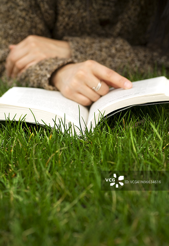 在草地上阅读书籍的人图片素材