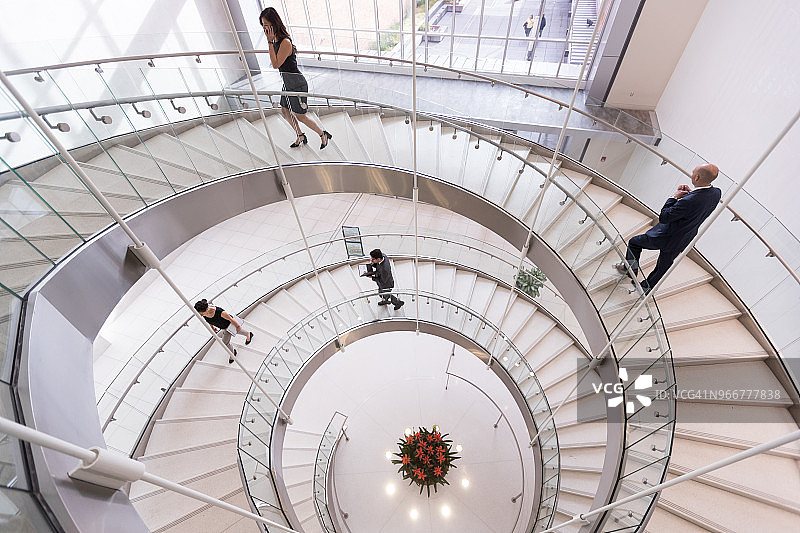 商务人士在现代会议中心走上楼梯图片素材