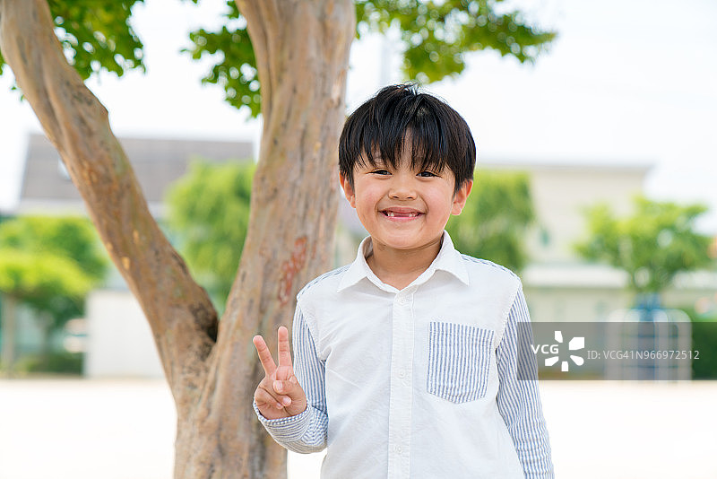做出和平手势的男孩肖像图片素材