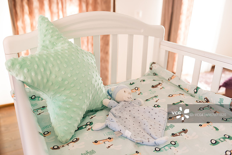 婴儿床上的泰迪熊特写，婴儿房图片素材