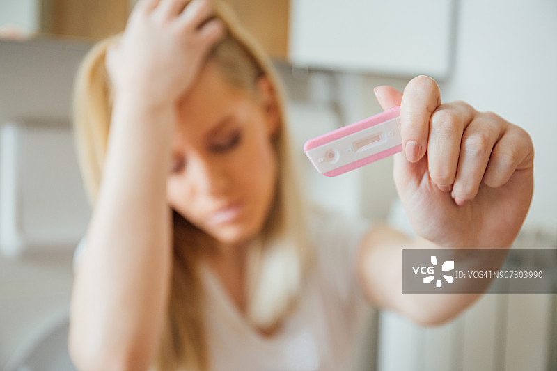 女人整理头发拿着验孕棒图片素材