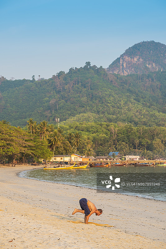 在泰国空旷海滩上练习瑜伽的男人图片素材