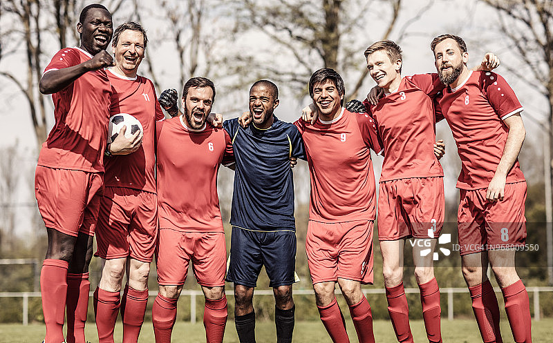 成年男子足球队庆祝赢得足球锦标赛图片素材