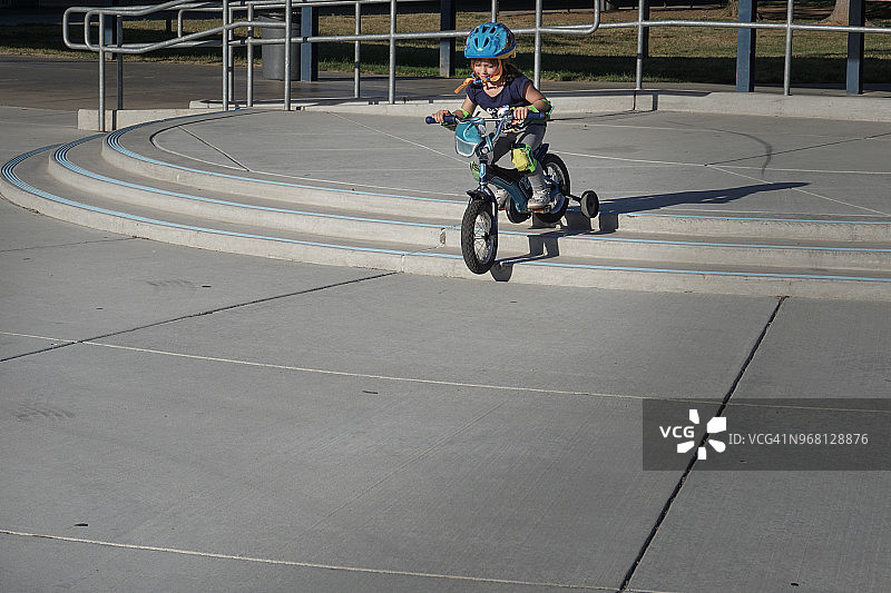 小女孩骑着三轮车下楼图片素材