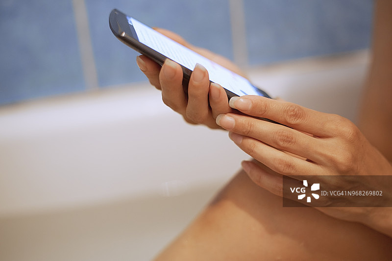 女人在浴缸里使用智能手机图片素材