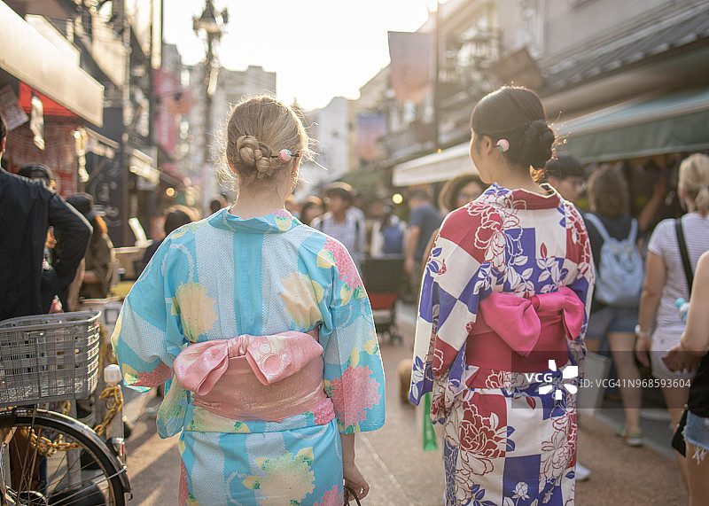 不同种族的女性朋友穿着浴衣走在日本传统小镇上图片素材