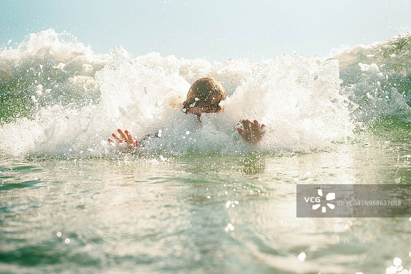 在海浪中游泳的男孩图片素材
