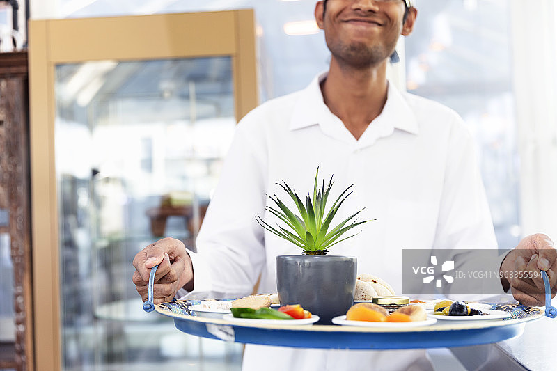 快乐的服务员端着餐盘图片素材