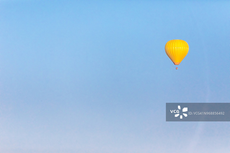 晴朗蓝天下黄色的热气球，德国巴伐利亚图片素材