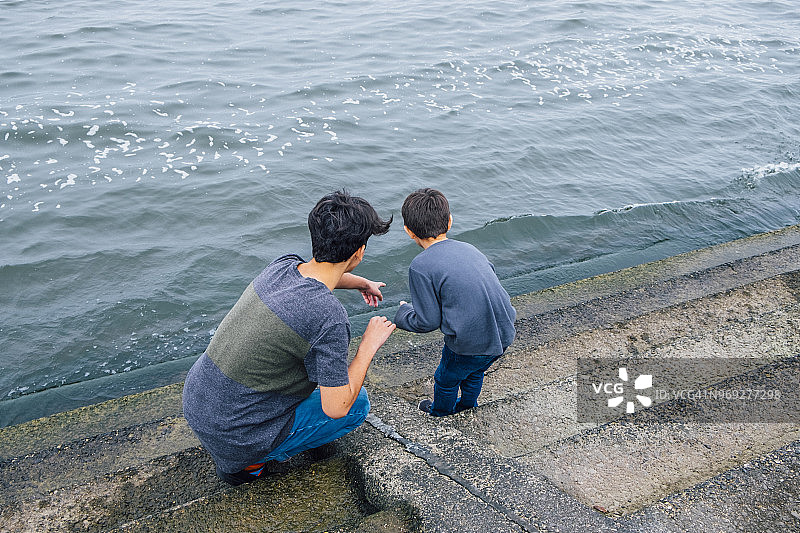 青少年男孩和弟弟在水边图片素材
