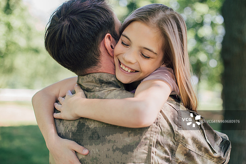 士兵与美丽的女儿拥抱图片素材