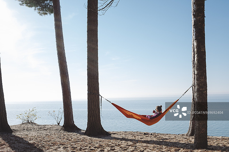 在吊床上看湖的女人图片素材