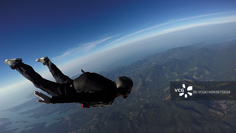 日出时分在海上跳伞的男人图片素材