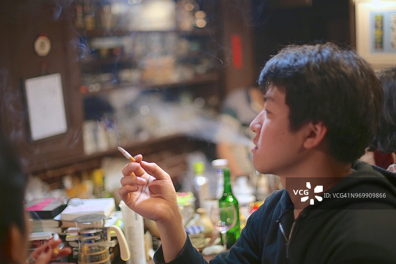 在酒吧吸烟的年轻男人图片素材