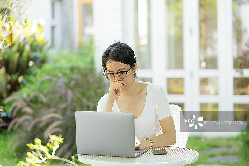 使用笔记本电脑后感到压力和头痛的亚洲男商人图片素材