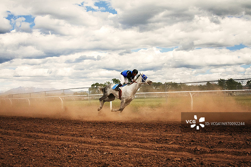 赛马比赛中骑师骑马的侧面照图片素材