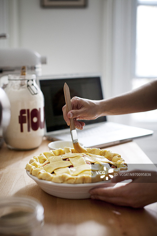 给馅饼刷蛋黄的手部特写图片素材