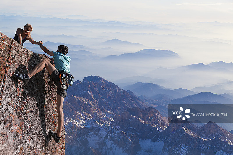 团队合作：情侣携手攀登图片素材