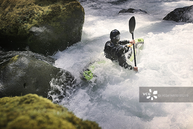 男子在河中划皮划艇（高角度）图片素材