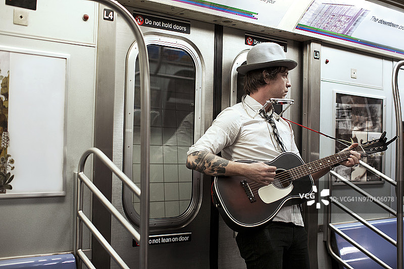 在地铁列车上弹吉他的街头音乐家图片素材