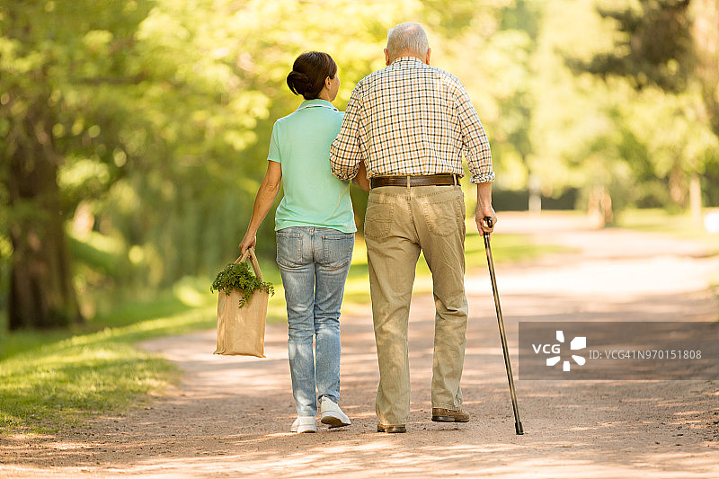 护理人员在公园帮助老年男子图片素材