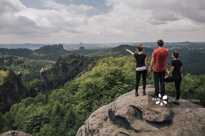 德国萨克森易北河砂岩山脉徒步旅行的朋友站在岩石上图片素材