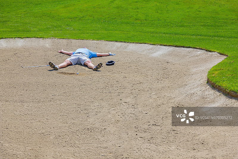 绝望的高尔夫球手躺在沙坑里图片素材